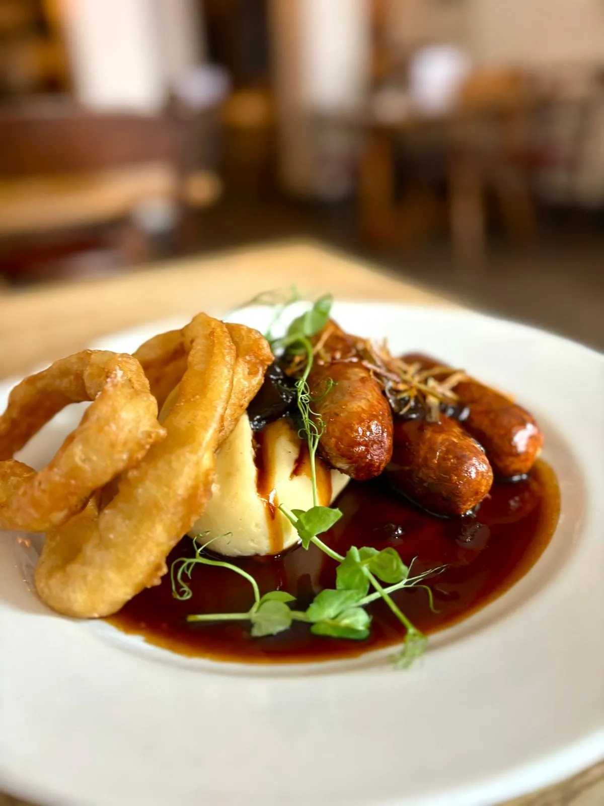 Sausages and mash with gravy and onion rings at The White Hart Wells